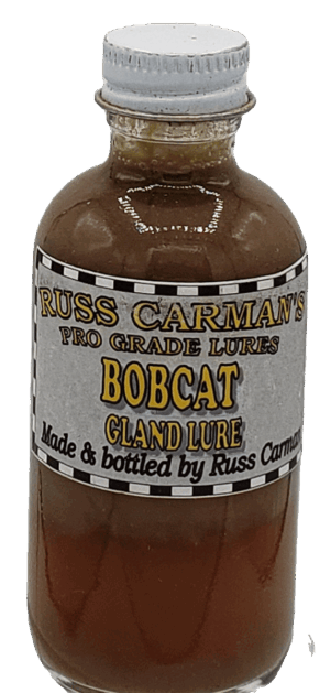 Small bottle labeled "Carman's Pro Grade Bobcat Gland Lure," with brown liquid, made and bottled by Russ Carman.