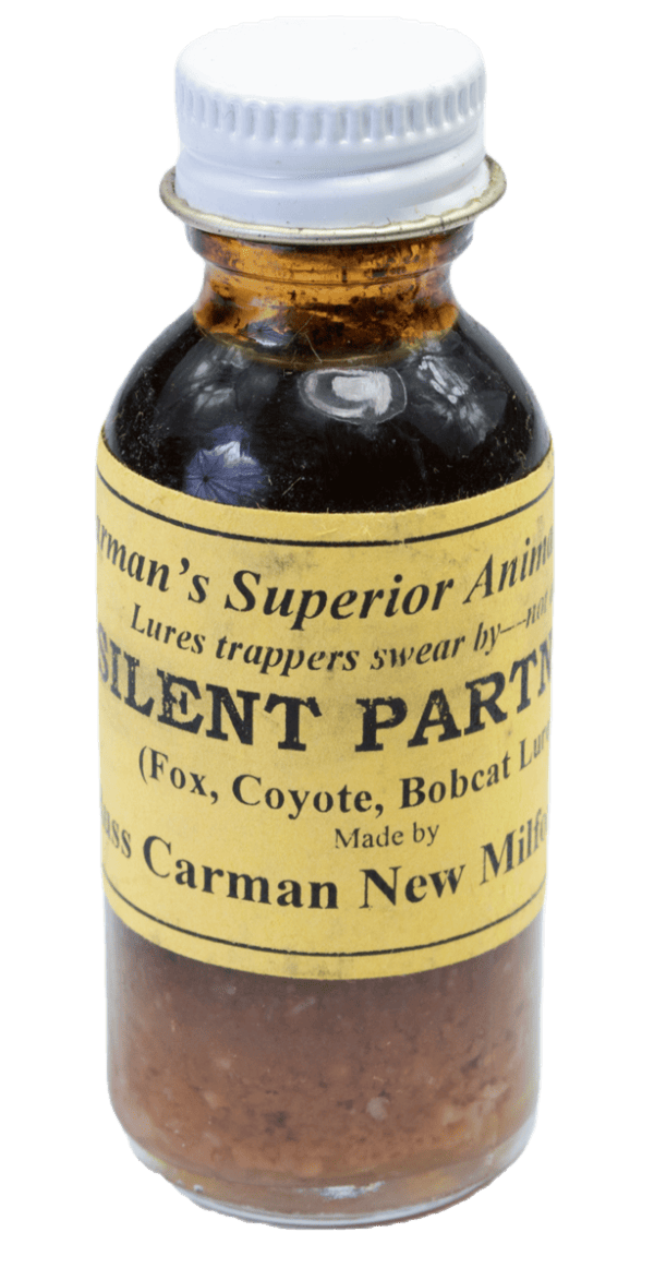 Small glass bottle labeled "Carman's Silent Partner Lure," used for trapping fox, coyote, and bobcat.