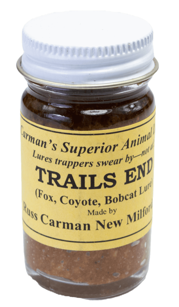 A small jar of Carman's Trails End Lure for trapping foxes, coyotes, and bobcats with a yellow label and silver lid.