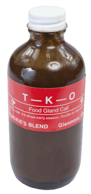 A brown glass bottle with a white cap, labeled "Blackie's T-K-O Lure," features Blackie's lure on a red background.